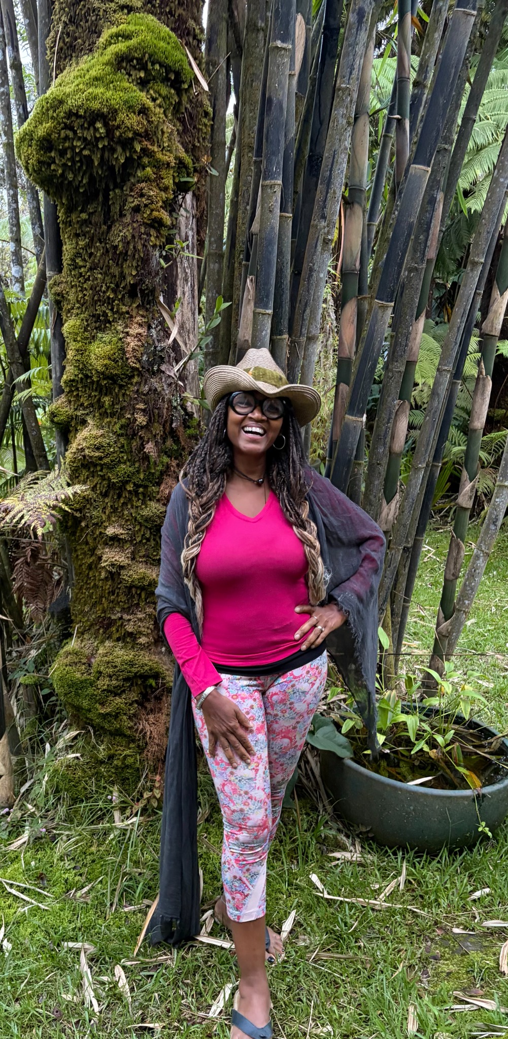 Dr. Allana Coffee standing beside bamboo and a moss-covered tree in Hawaiʻi